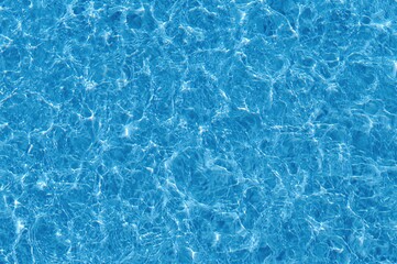 Obraz premium Abstract Summer Pattern of Water Ripples and Light Reflections on Blue Pool Surface