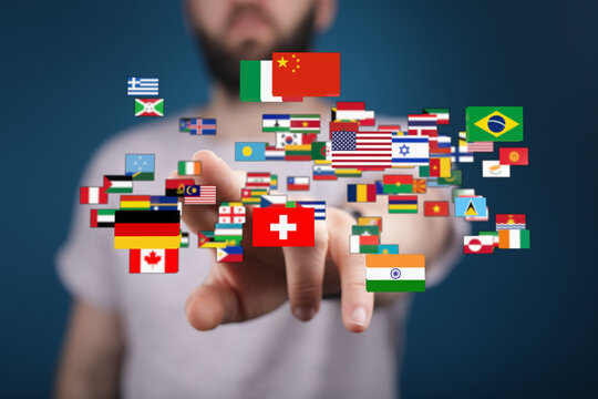 A hand pointing at a collection of world flags, symbolizing international relations, communication, travel, and global community. Represents uni