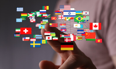 Digital representation of international connections. Hand touching flags from across the world, symbolizing global business, communication, and