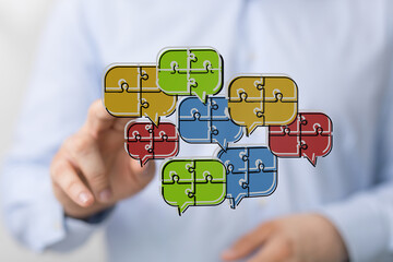 A visual representation of teamwork, collaboration, and communication. Speech bubbles with puzzle pieces highlighting ideas and connection.