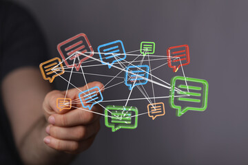 Conceptual image depicting digital communication, networking, and interconnected ideas with colorful speech bubbles linked together with a hand