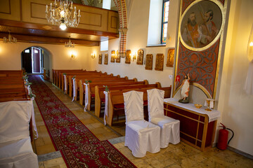 Interior of a church with white chairs and a red carpet