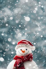 Snowman wearing red scarf and hat stands in falling snow during winter morning. Place for text