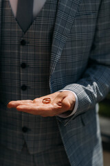 A man in a plaid jacket holds an engagement ring 7006.