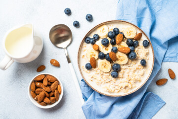 Oatmeal porridge with milk, bananas and blueberries.