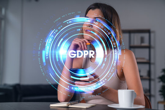Woman holding smartphone with GDPR hologram interface in modern home office, representing digital privacy and data protection concept..