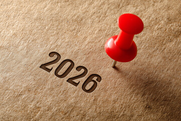 Red pin marks year 2026 on brown paper