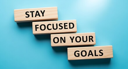 Wooden blocks spell out stay focused on your goals on blue background