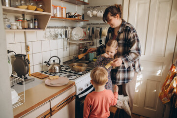 Mother preparing breakfast for her children in kitchen