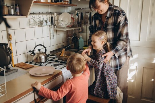 Mother and children cooking breakfast in kitchen at home