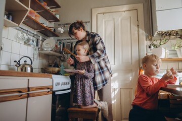 Mother teaching daughter cooking in domestic kitchen
