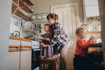 Mother teaching daughter cooking skills in home kitchen
