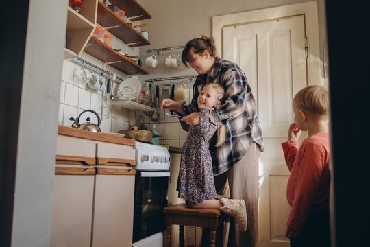Mother teaching daughter cooking in kitchen