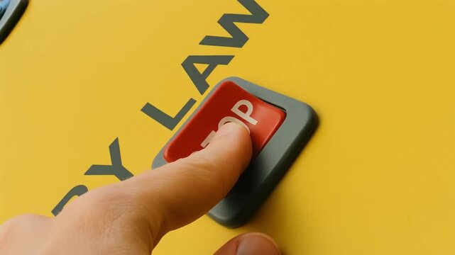 law restriction policy concept. Hand pressing a stop button on a yellow wall labeled by law.