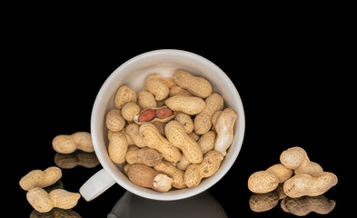 Unshelled peanuts isolated on black background, macro.