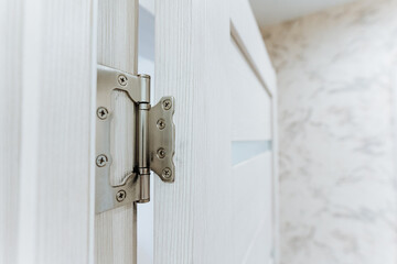 This image features a closeup view of a modern door hinge set within a beautifully bright interior...