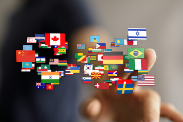 Image of a hand pointing at an array of international flags representing countries and global...