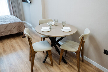 Experience a Stylish Dining Area featuring a Round Table accompanied by Chairs, all designed within a Modern Interior setting that exudes elegance and charm, making it perfect for any apartment