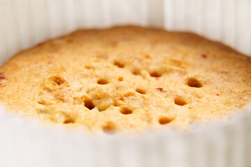 Round cookies with a hole pattern and red cranberry pieces in paper packaging