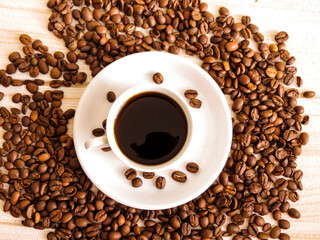 Cup of Coffee, Top view of coffee cup surrounded by roasted beans on wooden background. Minimalistic design for morning, cafe, or branding projects. Part of the Coffee Theme Pack series.