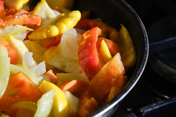 Fresh raw fried vegetables in a frying pan, close up. Shallow depth of fieled