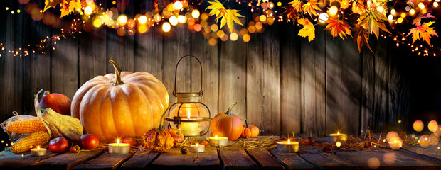 Thanksgiving - Pumpkins And Corncobs On Wooden Table With Rustic Garland And Defocused Abstract...