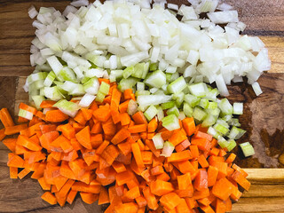 Carrot, Celery and Onion, on a wooden cutting board.