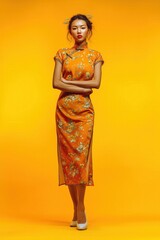 Elegant Chinese Woman in Traditional Dress Posing Against Vibrant Yellow Background in Full Body Standing Shot