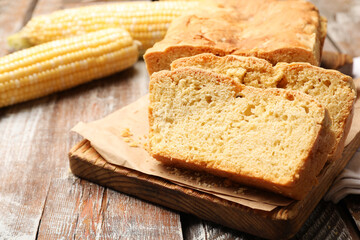Freshly baked cut cornbread on wooden table, closeup