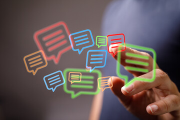 Finger tapping holographic speech bubbles showcasing digital communication and network connections.
