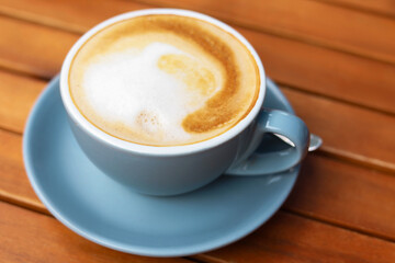 Cup of aromatic coffee on wooden table, closeup