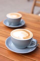 Cups of aromatic coffee on wooden table, closeup