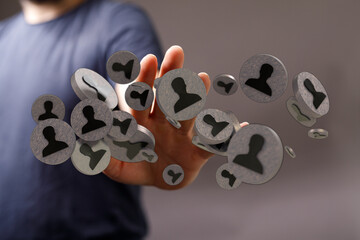 Conceptual hand reaching to stylized person icons. Illustrates networking, human resources,...