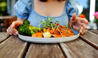 Girl Eating Vegetable Dish At Street Restaurant