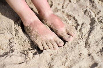 Bare feet on warm beach sand