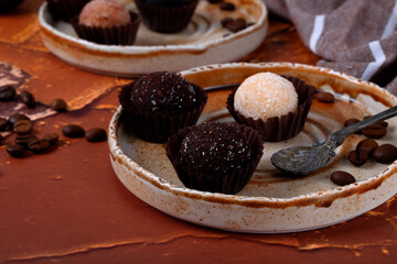 Candies made from dried fruits and nuts on a ceramic plate. Healthy dessert with coffee flavor