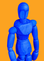 A wooden mannequin figure closeup in blue isolated on an orange background