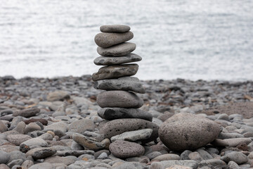 Pile of zen stones on the beach with ocean in the background