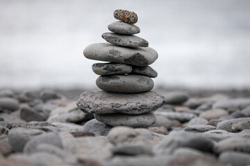 Pile of zen stones on the beach with ocean in the background