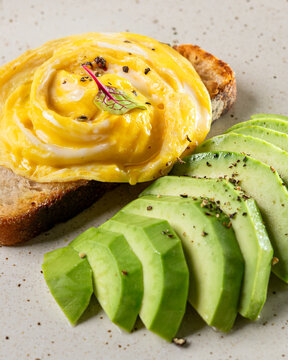 Close-Up of Creamy Scrambled Eggs on Toast with Fresh Avocado &ndash; Healthy Breakfast