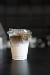 Iced charcoal latte in a clear plastic cup, showing the texture and refreshing look of the drink