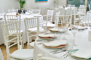 Elegant Dining Setup Featuring White Chairs and Classic Tableware in a Cozy Restaurant Ambiance with Tasteful Decor for Memorable Gatherings
