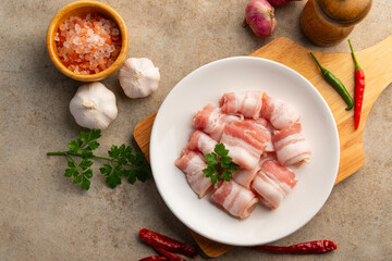 Raw fresh pork thin,Rolled sliced pork belly in white plate.Top view.