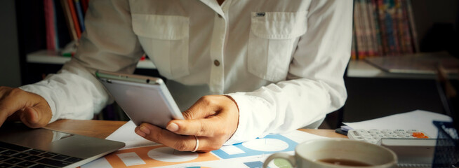 Business and finance planning concept.Financial adviser planning and working on laptop, and using smartphone. Professional businesswoman discuss and review annual report at office-banner image.