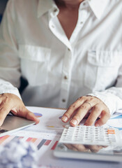 Business and finance planning concept.Financial adviser planning and working on laptop, and using calculator. Professional businesswoman discuss and review annual report at office-vertical image.