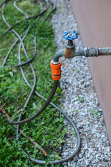 faucet with valve and hose for watering plants in the garden	
