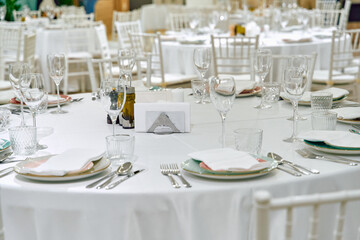 Elegant Dining Setup Featuring White Tablecloths, Fine Glassware, and Tastefully Arranged Tableware for a Formal Event or Celebration