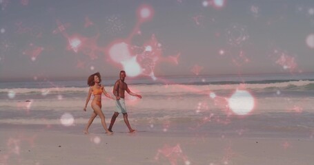 Strolling couple in bikini and swim trunks moving along beach shoreline, with pink star overlay
