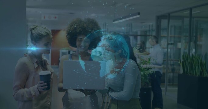 Collaborating women discussing 3D globe projection on laptop in office lounge, with coffee cup