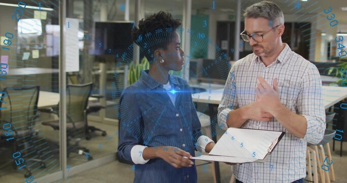Coworkers discussing digital interface overlay near glass-wall office desks, holding clipboard